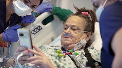 Lisa Pisano looks at photos of her dog after her surgeries at NYU Langone Health in New York on Monday, April 22, 2024. Doctors had to remove a transplanted pig kidney from Pisano and put her back on dialysis just 47 days later – because the heart disease she also suffers damaged the new organ. Pisano was only the second patient ever to receive a kidney from a gene-edited pig, and NYU Langone Health announced Friday, May 31, that she is stable after removal of the kidney.