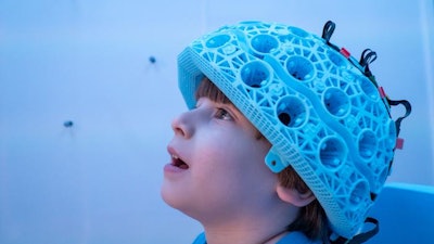 Child wearing one of the MEG-OPM helmet style brain scanners.