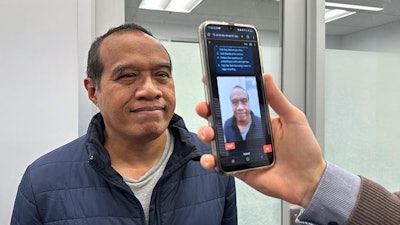 PhD scholar Guilherme Camargo de Oliveira (right) demonstrates the face screening tool with Visiting Associate Professor Nemuel Daniel Pah from RMIT University.