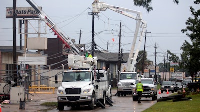 Utility crews work to restore electricity in Houston, Thursday, July 11, 2024. Officials say about 500,000 customers still won't have electricity into next week as wide outages from Hurricane Beryl persist.