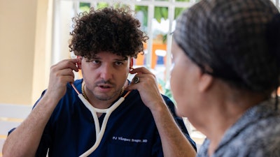 Dr. Pedro Juan Vázquez, better known by his stage name PJ Sin Suela, attends to a patient in Loiza, Puerto Rico, Saturday, May 25, 2024. The 34-year-old doctor travels from the San Juan capital to the island’s southern and central regions to treat communities struggling in the aftermath of hurricanes. After hanging up his doctor’s scrubs, Vázquez spends his time producing new music that relays the island’s issues.