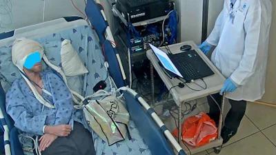 An image from the experiment of the speech neuroprosthesis (a.k.a speech brain-computer interface). It shows the participant who is completely silent, with his mouth closed, imagining saying a syllable. The laptop 'says' the syllable for him.