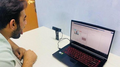 A researcher demonstrates how a camera captures images of the tongue and analyzes it for disease.