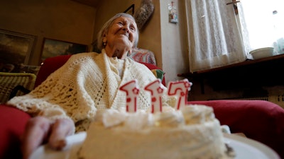 Emma Morano holds a cake with candles marking 117 years on the day of her birthday, Nov. 29, 2016, in Verbania, Italy.