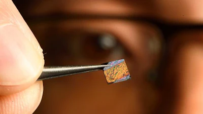 Johns Hopkins research Peng Zheng with the heart of the invention, a tiny chip with a groundbreaking nanostructured surface on which blood is tested.