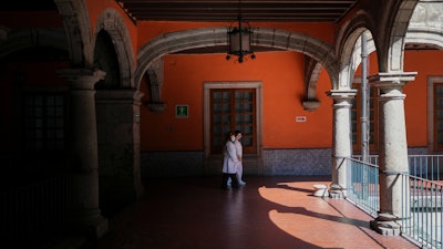 Medical staff walk through an outdoor passage of the Hospital de Jesus, in Mexico City, Friday, Nov. 8, 2024.