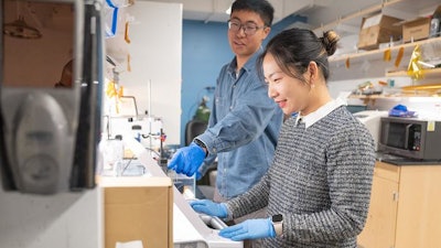 Caltech graduate students and lead authors of the microrobots paper, Hong Han and Xiaotian Ma, collaborate with Professor Wei Gao on experiments involving ultrasound imaging-guided acoustic propulsion of the microrobots.