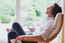 A man listens to music on his own at home.