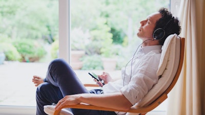 A man listens to music on his own at home.