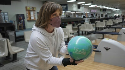 Susan Scarbro bowls while wearing a mask in Little River, S.C. on Jan. 3, 2025.