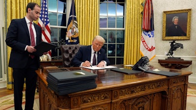 President Donald Trump signs an executive order withdrawing the U.S. from the World Health Organization in the Oval Office of the White House, Monday, Jan. 20, 2025, in Washington.