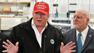 President Donald Trump speaks to members of the press as Director Robert Redfield, right, looks at the headquarters of the Centers for Disease Control and Prevention in Atlanta, March 6, 2020.