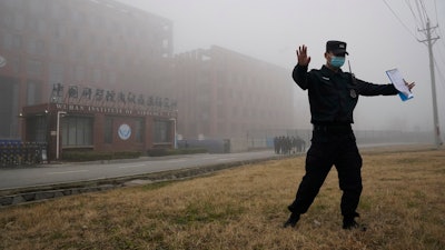A security person moves journalists away from the Wuhan Institute of Virology after a World Health Organization team arrived for a field visit in Wuhan in China's Hubei province, Feb. 3, 2021.