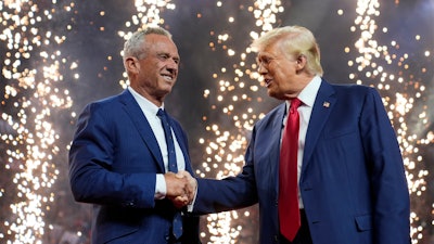 Republican presidential nominee former President Donald Trump shakes hands with Independent presidential candidate Robert F. Kennedy Jr. at a campaign rally at the Desert Diamond Arena, Friday, Aug. 23, 2024, in Glendale, Ariz.