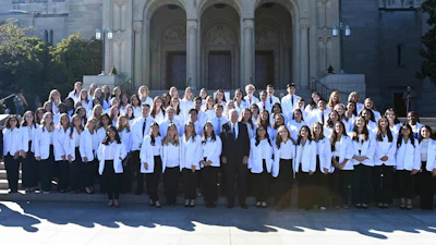 In this photo provided by The Catholic University, co-founder of The Carlyle Group, Bill Conway, center, who plans to give $1 billion to support nursing programs across the country, poses with nursing students from The Catholic University of America in Washington, Oct. 18, 2024, one of the 22 nursing schools that his nonprofit currently supports.