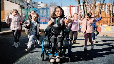 A girl uses the exoskeleton in her schoolyard.