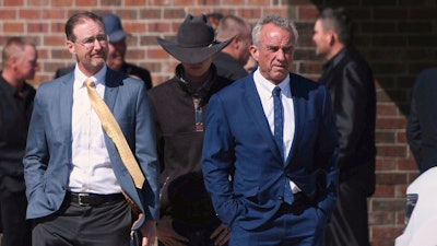 Health and Human Services Secretary Robert F. Kennedy Jr., right, arrives at Reinlander Mennonite Church in Seminole, Texas, on Sunday, April 6, 2025, after a second measles-related death in the state.