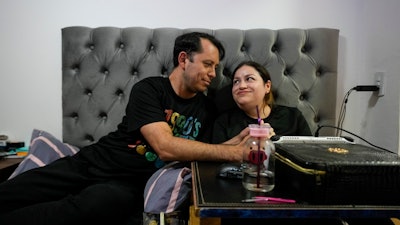 Susana Moreira, 41, a degenerative muscular dystrophy patient, looks at her husband in her bedroom in Santiago, Chile, Thursday, April 10, 2025.