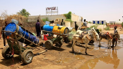 People fill water containers at a distribution point due to water outages in Khartoum, Sudan, Sunday, May 25, 2025.