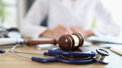 A judges gavel atop a stethoscope.
