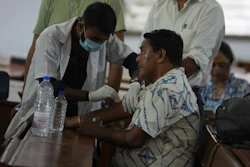 A health worker take DNA sample of a family member of a victim of an airplane that crashed in India's northwestern city of Ahmedabad in Gujarat state, Friday, June 13, 2025.