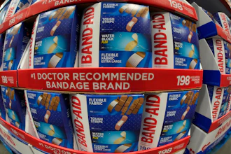 Band-Aid bandage boxes stacked in store display, showing flexible fabric and water block varieties