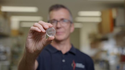 Griffith University's Professor James St John holding a nerve bridge.