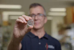 Griffith University's Professor James St John holding a nerve bridge.