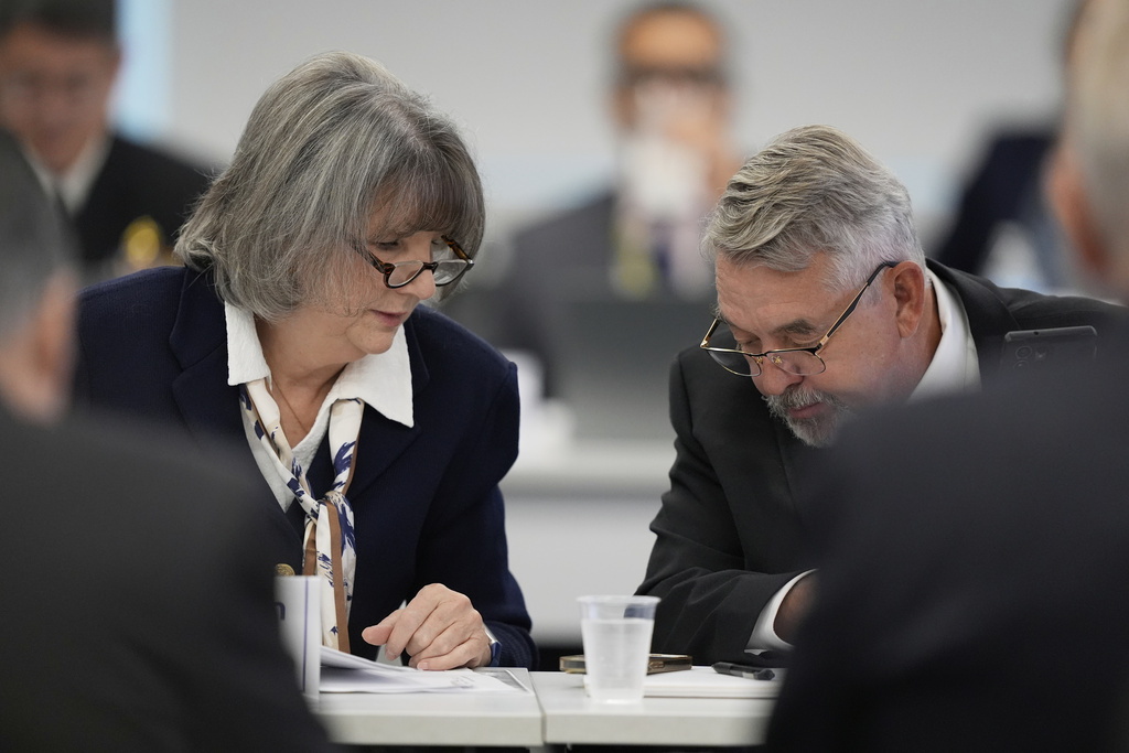 Committee members, Dr. Joseph Hibbeln, right, talks with Vicky Pebsworth, left, during a meeting of the Advisory Committee on Immunization Practices at the CDC on Thursday, Sept. 18, 2025, in Chamblee, Ga.