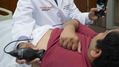 Partho Sengupta using the portable ultrasound device on colleague.