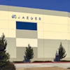 Jaeger corporate building with yellow and gray exterior and pine trees