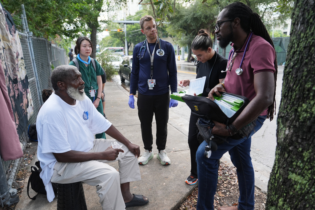 Dr. Inaki Bent, right, talks with Jonas Richards, left, while working with the Miami Street Medicine team to provide medical services to homeless people, Saturday, Aug. 23, 2025, in Miami.
