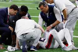 New England Patriots head coach Mike Vrabel, second from right, checks on cornerback Marcus Jones after an injury during the second half of an NFL football game against the New Orleans Saints, Sunday, Oct. 12, 2025, in New Orleans.