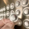 White circular concave buttons or discs arranged in repeating pattern