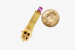 The thin, flexible, wireless device sits next to a quarter for scale. Device emits complex patterns of light (shown here as an 'N') to transmit information directly to the brain.
