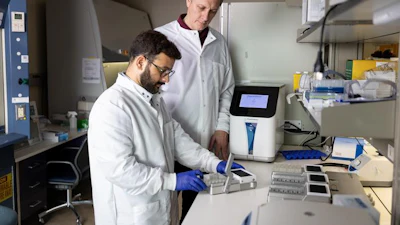 Dr. Chander Negi prepares samples using the PhysioMimix LC12 liver-on-a-chip system as Dr. Ivan Rusyn looks on in their Texas A&M research laboratory.