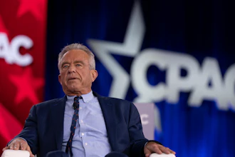 Middle-aged man in dark suit speaking at CPAC political conference podium