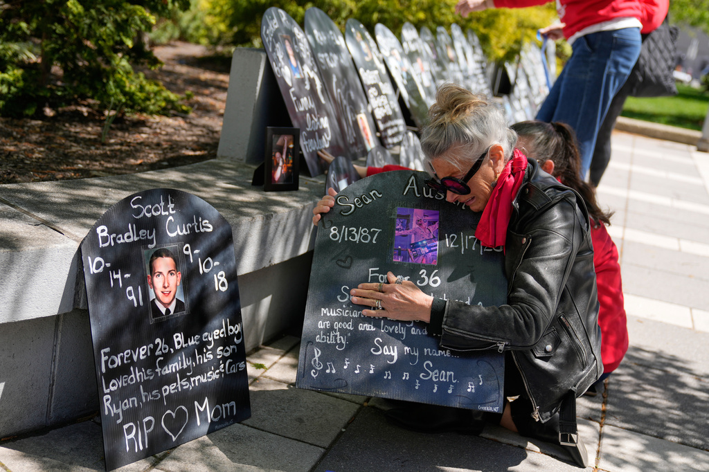 Memorial tribute with handwritten chalkboards honoring loved ones at outdoor gathering