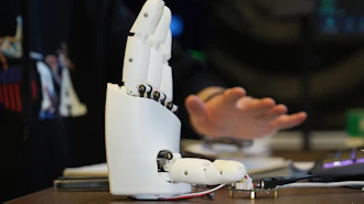 Massachusetts Institute of Technology mechanical engineering graduate student Dian Li demonstrates how an ultrasound wristband can help a robotic hand mimic full hand motions in Cambridge, Mass, on Tuesday, April 14, 2026.