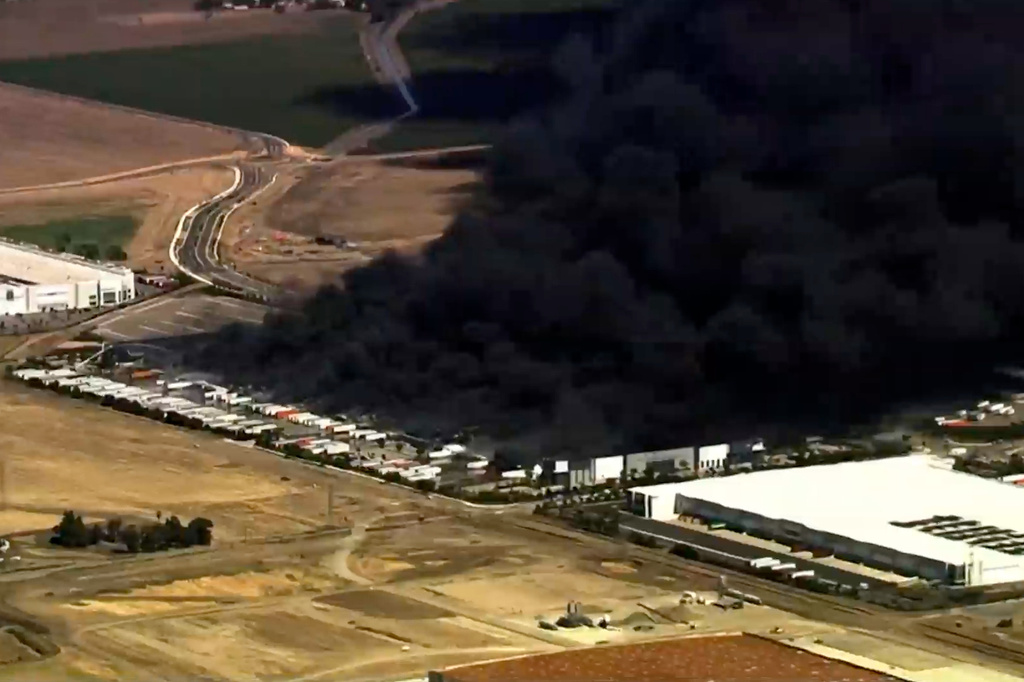 This image from aerial video shows black smoke pouring into the sky from a fire at a medical equipment warehouse in Tracy, Calif., Thursday, June 11, 2026.