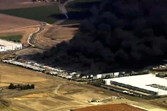 This image from aerial video shows black smoke pouring into the sky from a fire at a medical equipment warehouse in Tracy, Calif., Thursday, June 11, 2026.