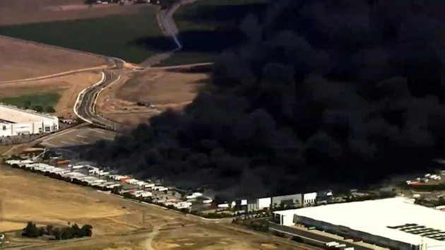 This image from aerial video shows black smoke pouring into the sky from a fire at a medical equipment warehouse in Tracy, Calif., Thursday, June 11, 2026.