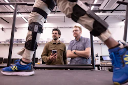 Nikhil Divekar, a postdoctoral research fellow in the Locomotor Control Systems Laboratory, demonstrates the knee exoskeleton on raised platform in the lab while fellow postdoc Ernesto Hernandez Hinojosa and professor Robert Gregg observe.