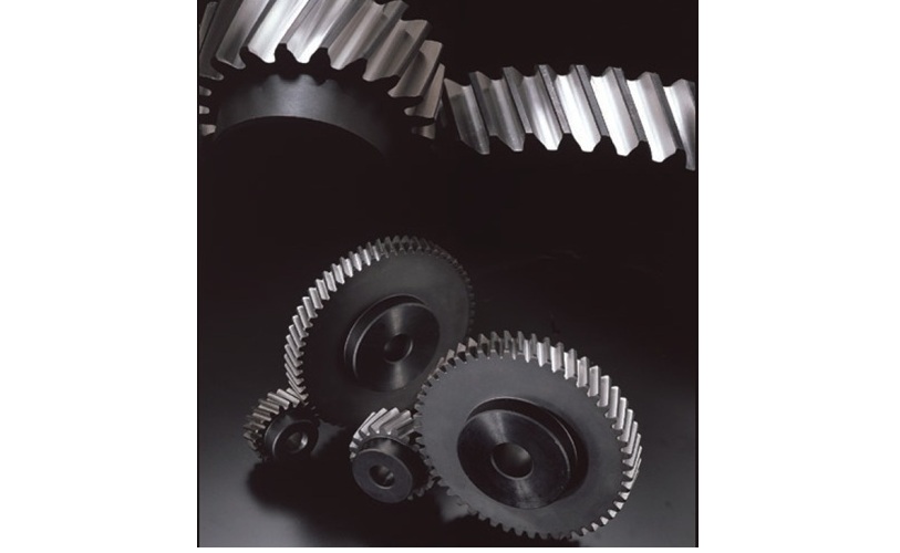 Metallic gears and cogwheels arranged on dark background, representing mechanical engineering and industrial machinery