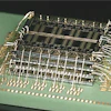 A stacked die assembly with waterfall wirebonds produced at Promex. Packing multiple die vertically within a tight mechanical envelope requires every material and process variable — spacer thickness, die attach film bondline, wire bond arc height — to be engineered as a system, not selected independently.