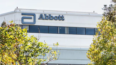 Abbott corporate headquarters building with blue logo signage and surrounding green landscaping
