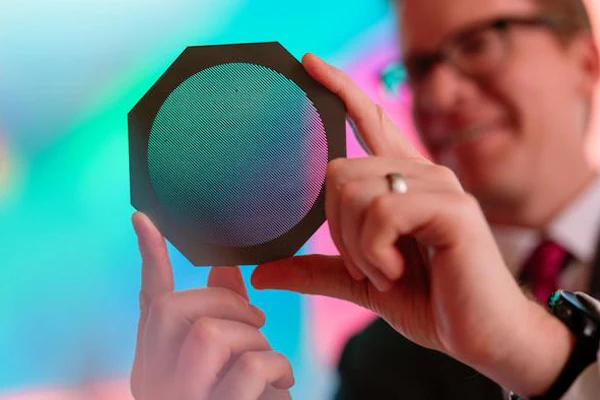 Radiation oncology medical physicist Dr. Michael Grams holds a device called a tungsten collimator that divides a conventional radiation beam into submillimeter-wide beamlets.