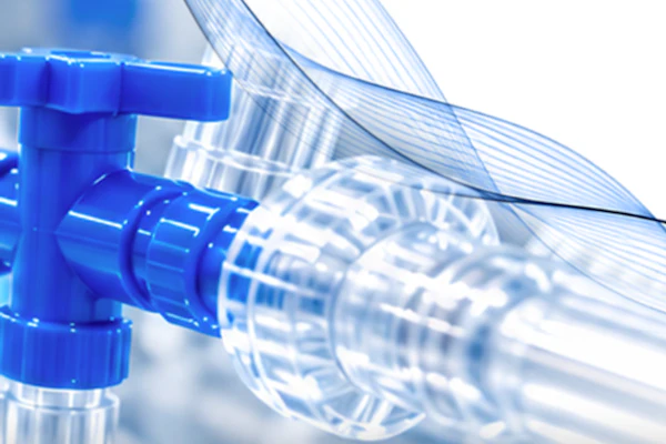 Blue plastic valve with transparent tubing and water droplets against white background