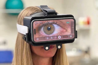 Woman wearing VR headset displaying close-up eye imagery on screen in fitness studio setting