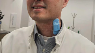 Professional man in white lab coat and striped shirt smiling in modern office environment